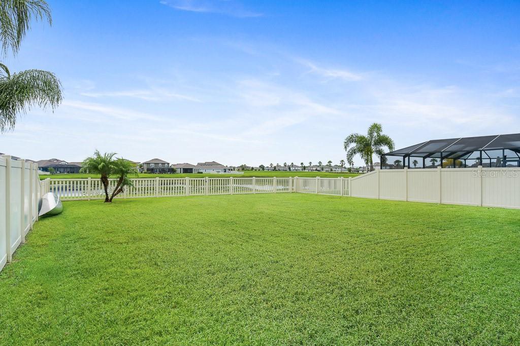 large fenced yard with pond views