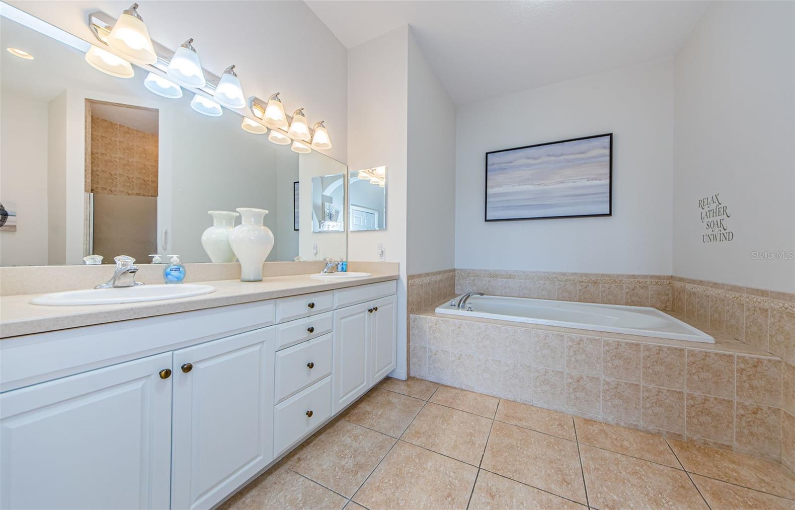 His & Her vanity with soaking tub and separate Step-in shower.