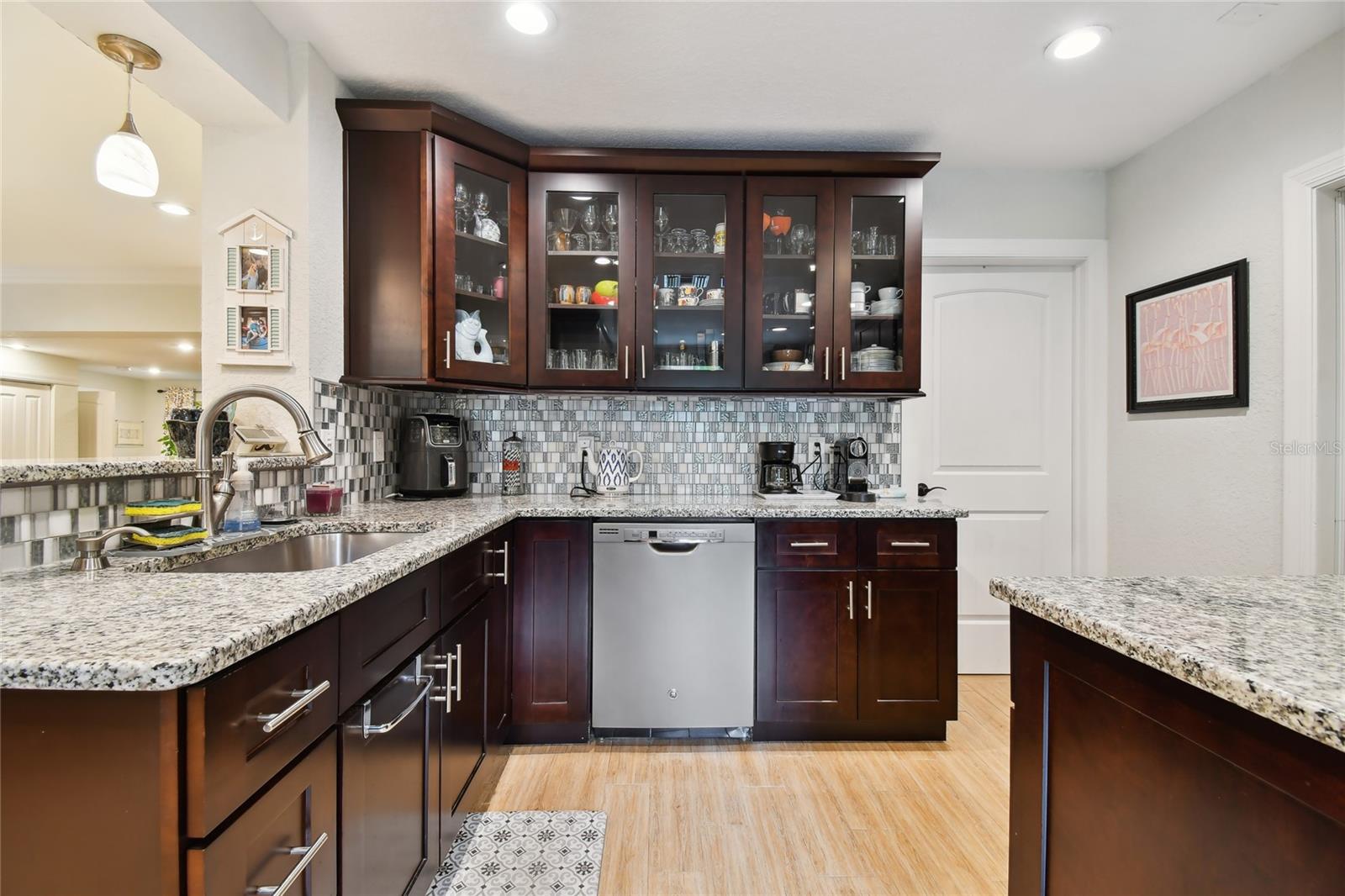 Laundry room is the door to the right of cabinets.