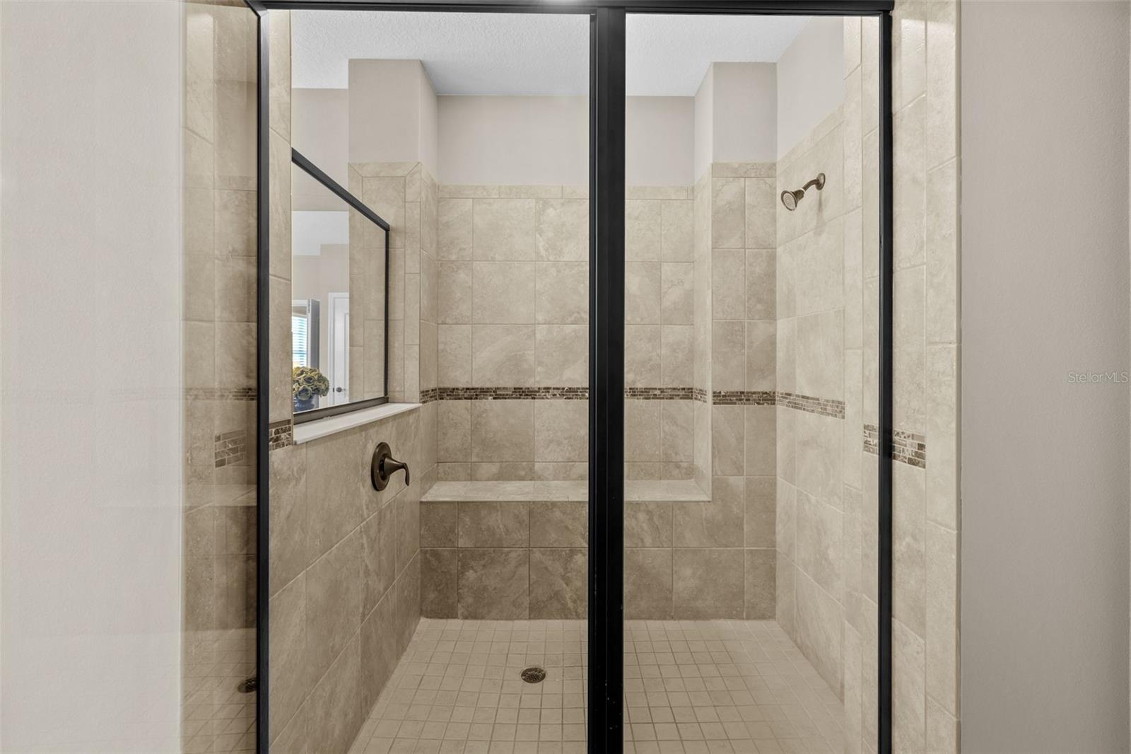 Tiled master shower with built-in shower bench