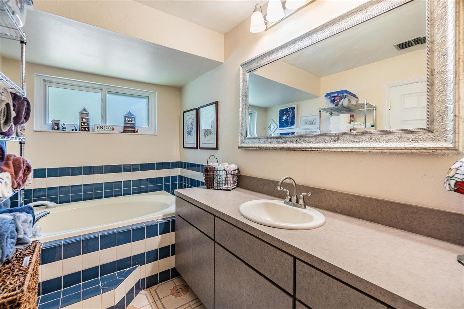 Primary ensuite bath with soaking tub, large vanity, and stand up shower