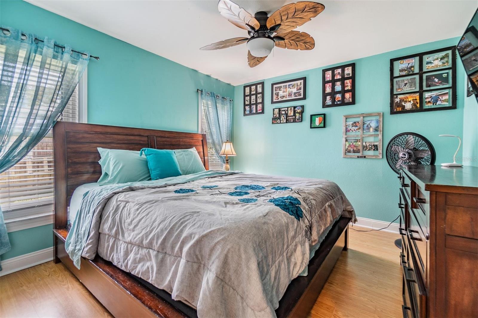 Second bedroom with wall closet, laminate floors, decorative fan and wall closet