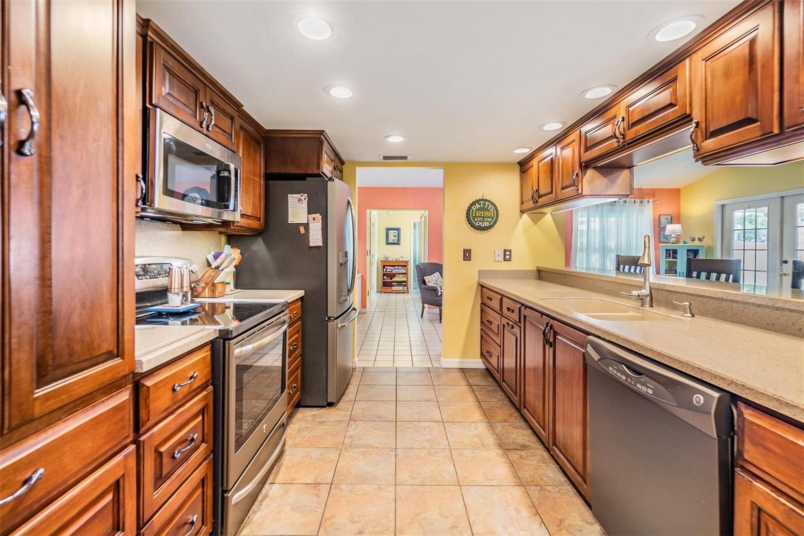 Beautifully updated kitchen with new stainless steel appliances, Corian countertops, recessed lighting, breakfast bar, and large walk-in pantry