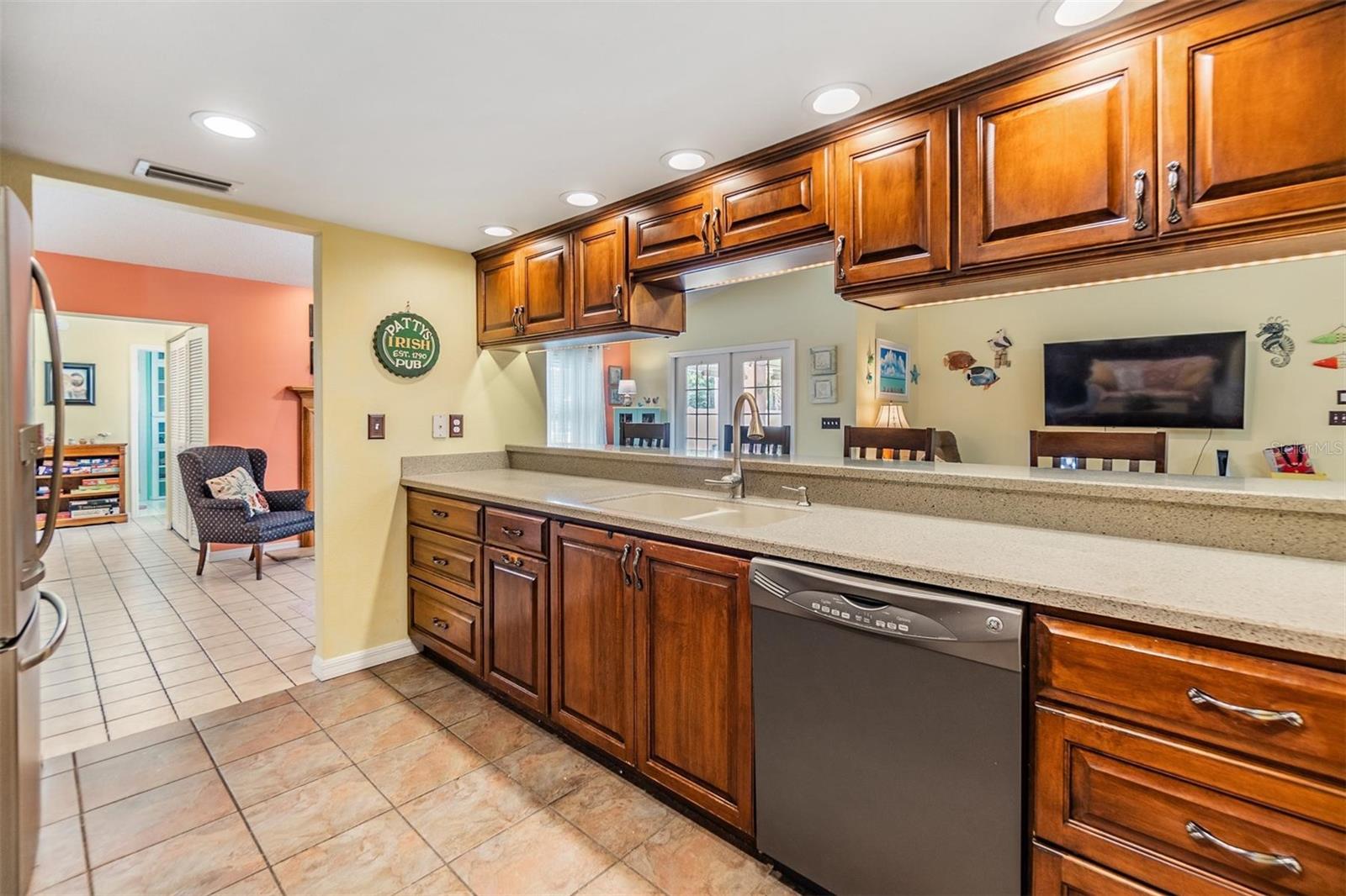 Beautifully updated kitchen with new stainless steel appliances, Corian countertops, recessed lighting, breakfast bar, and large walk-in pantry