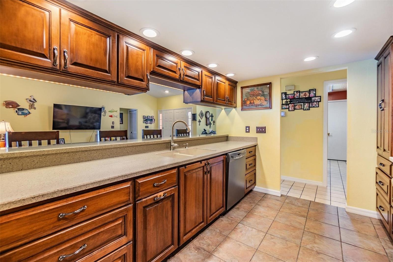 Beautifully updated kitchen with new stainless steel appliances, Corian countertops, recessed lighting, breakfast bar, and large walk-in pantry