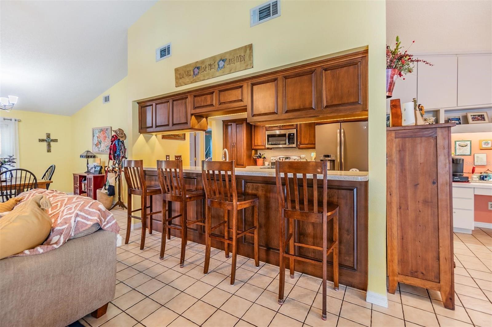 Beautifully updated kitchen with new stainless steel appliances, Corian countertops, recessed lighting, breakfast bar, and large walk-in pantry