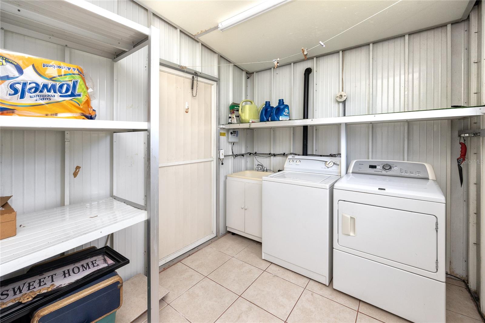 Enclosed laundry room with space to store all the extras.