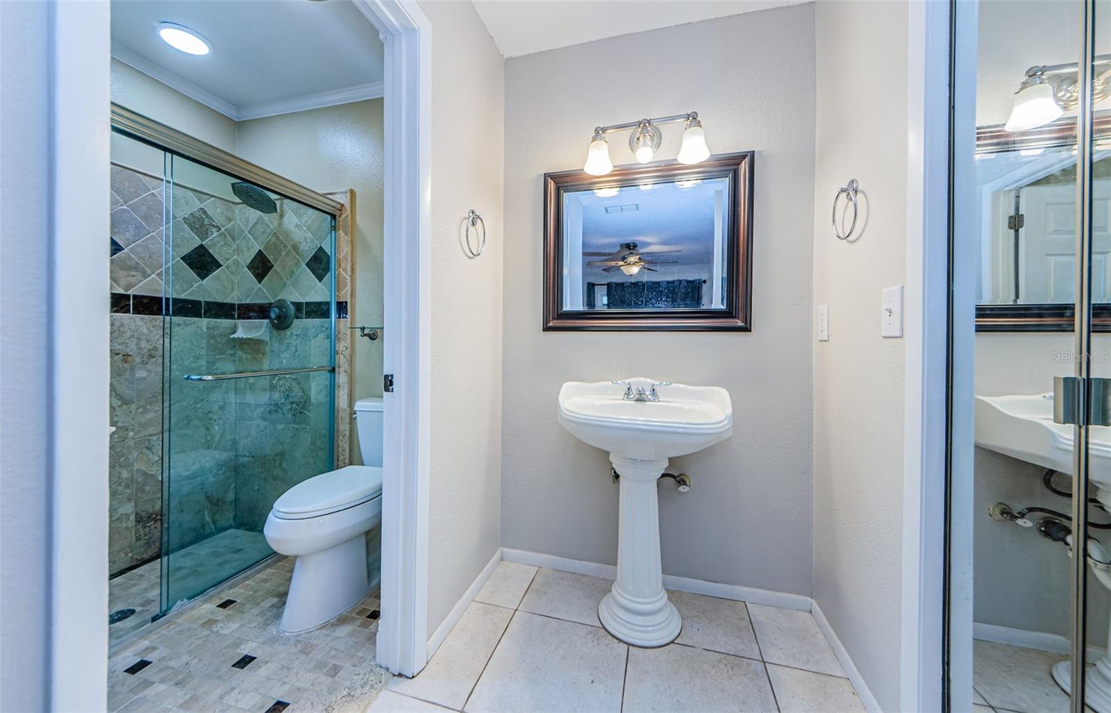 Beautifully updated Primary Bathroom, to the right is a large walk in closet, and to the left is a privacy door to the Shower and Commode