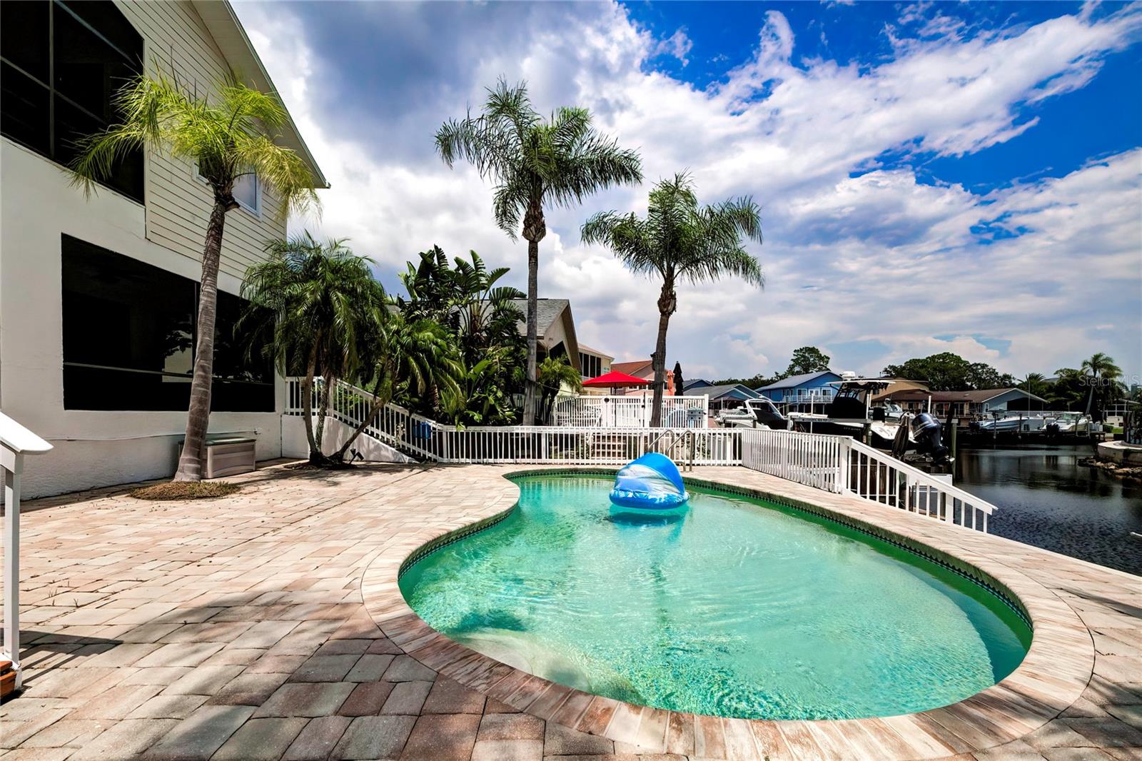 Kidney shaped pool with pavers.