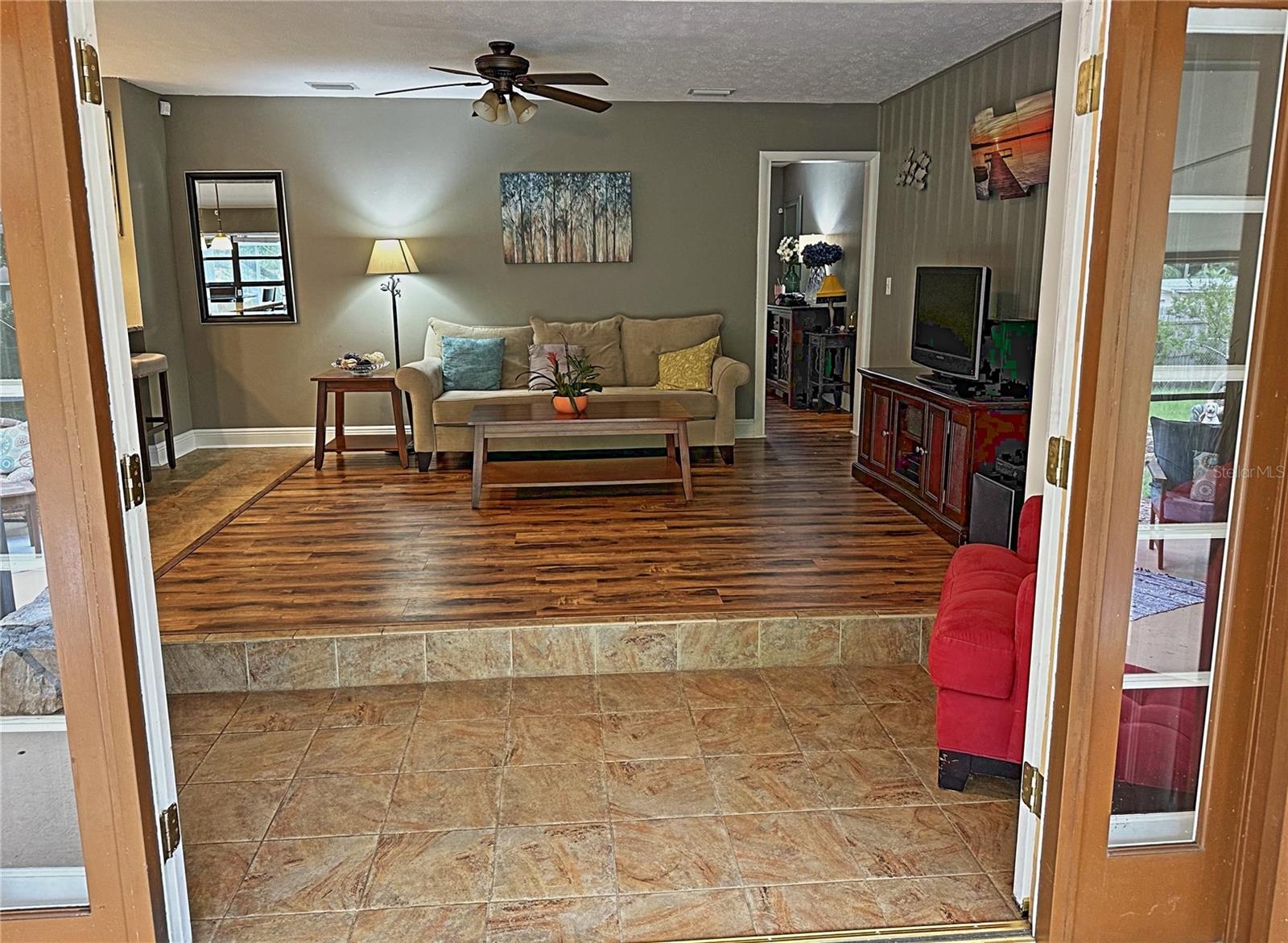 The living room french doors open onto the pool enclosure.