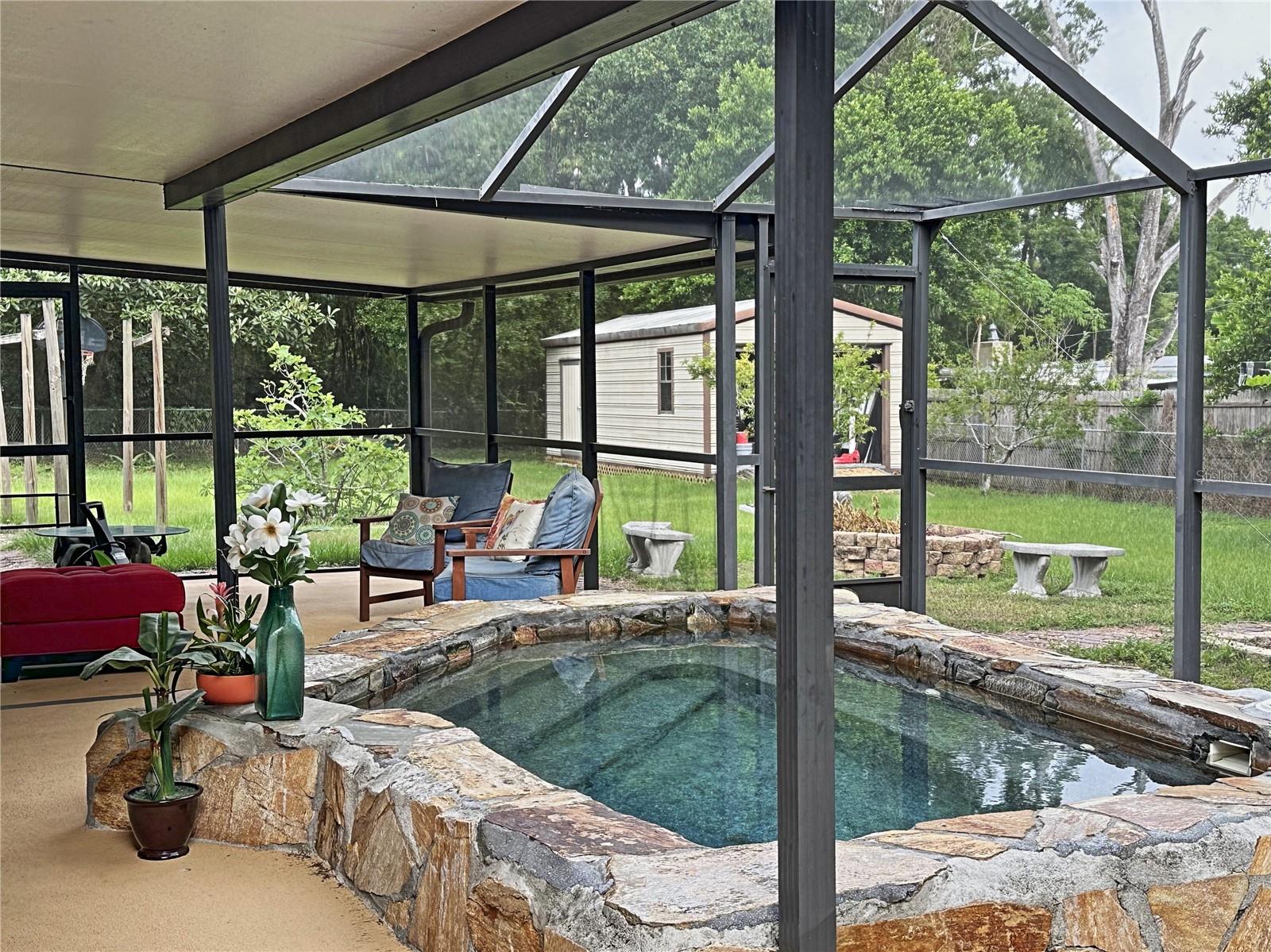 Note the screened lanai has a partial roof.  You get a sense of the huge yard as you see the work shed far in the distance.