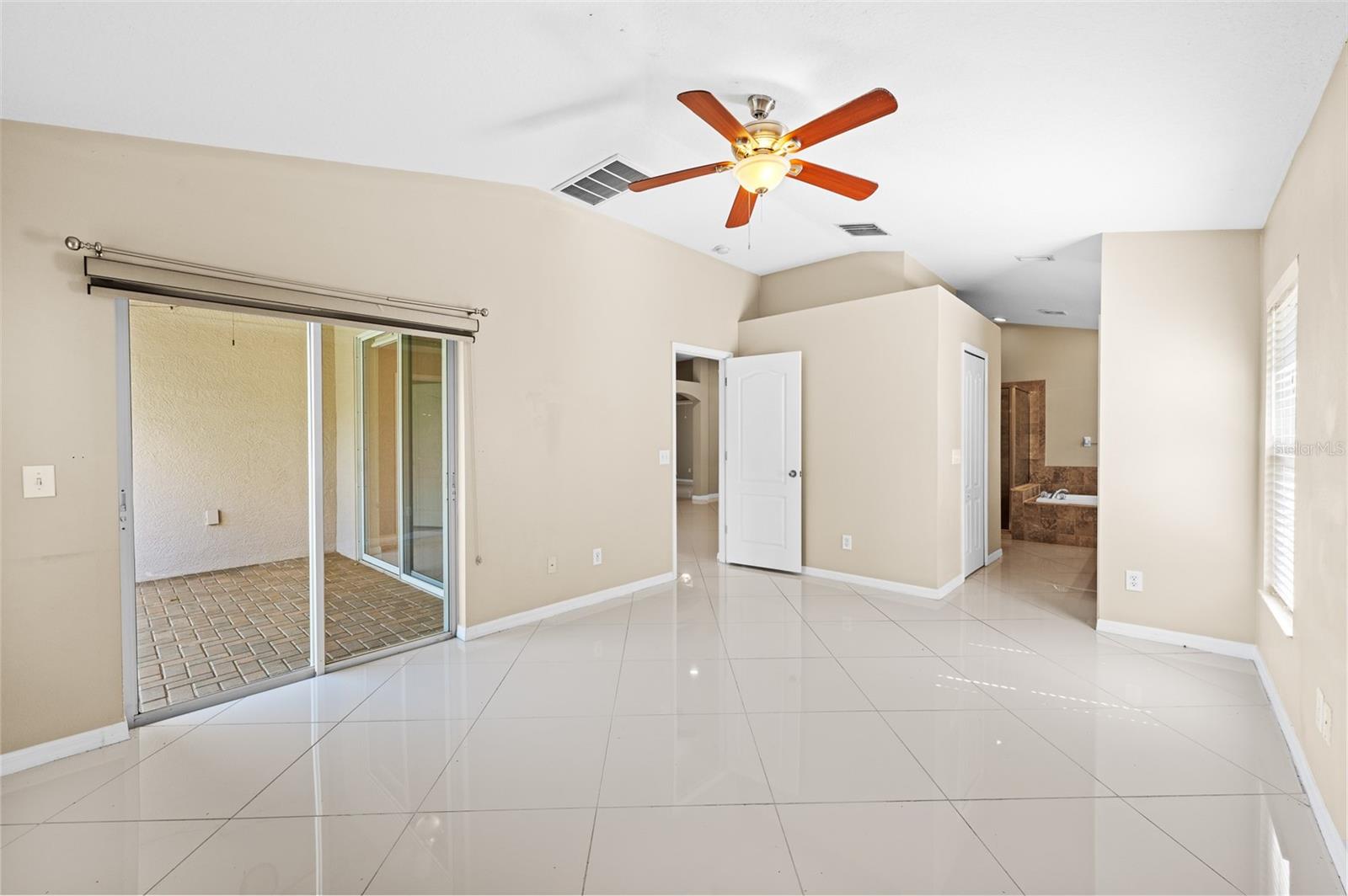 Primary Bedroom with doors out to Lanai and ensuite bathroom