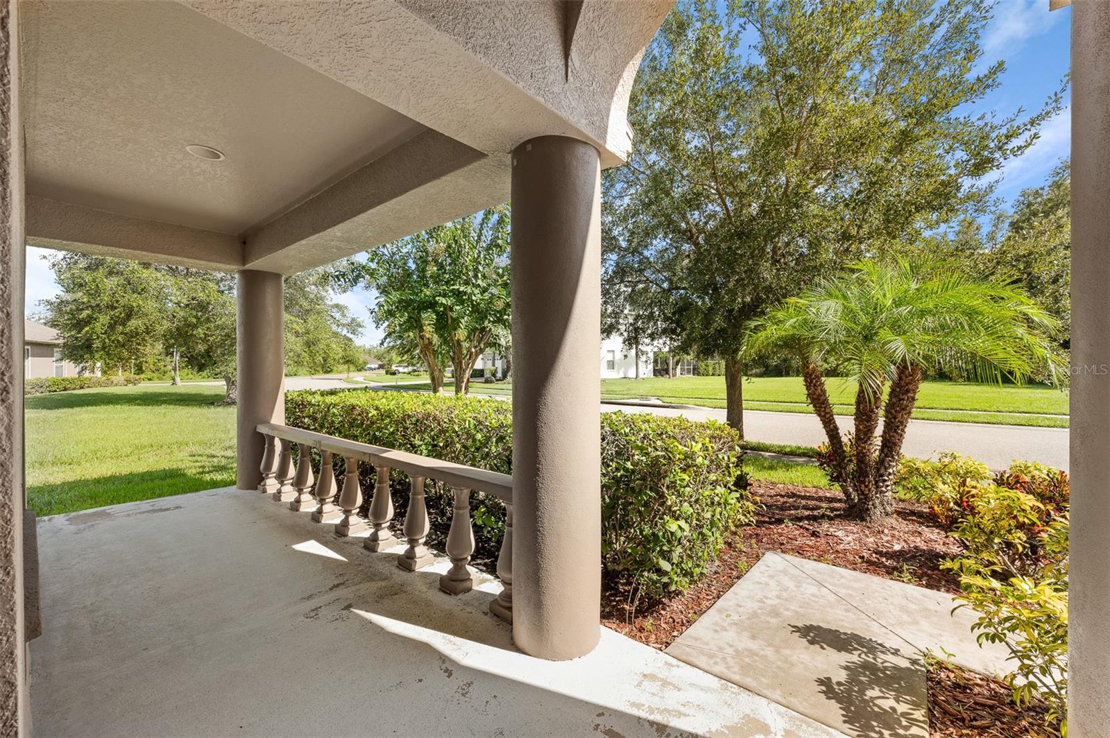 Covered front porch overlooking beautifully landscaped yard