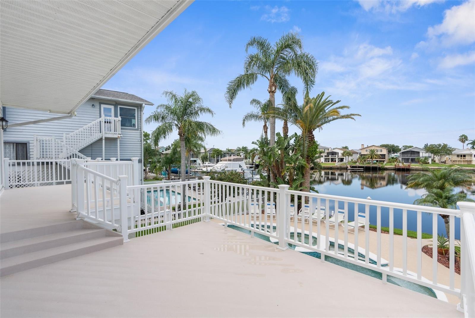 deck off main level space on second level, views of the water and pool area