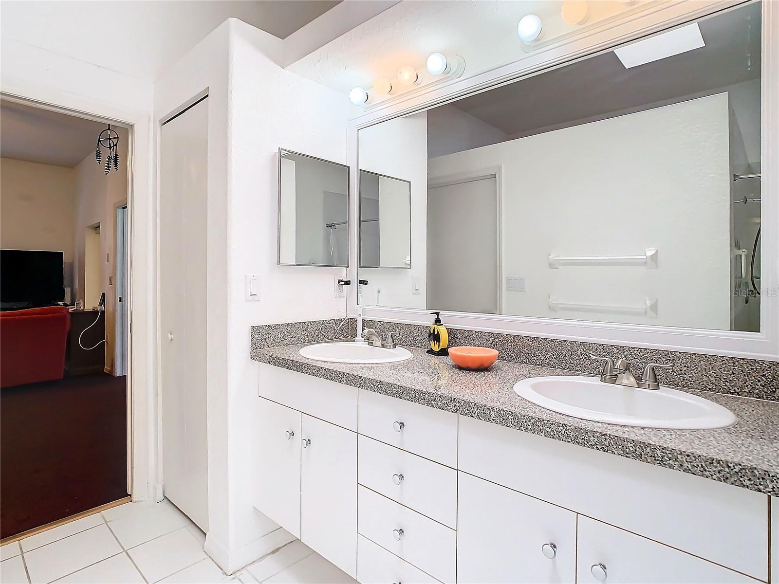 The primary bathroom has a pocket door to allow for extra space. A linen closet, double sink high boy vanity with a large mirror give you exceptional space to get yourself ready for the day. Look at all the drawers and cabinets.