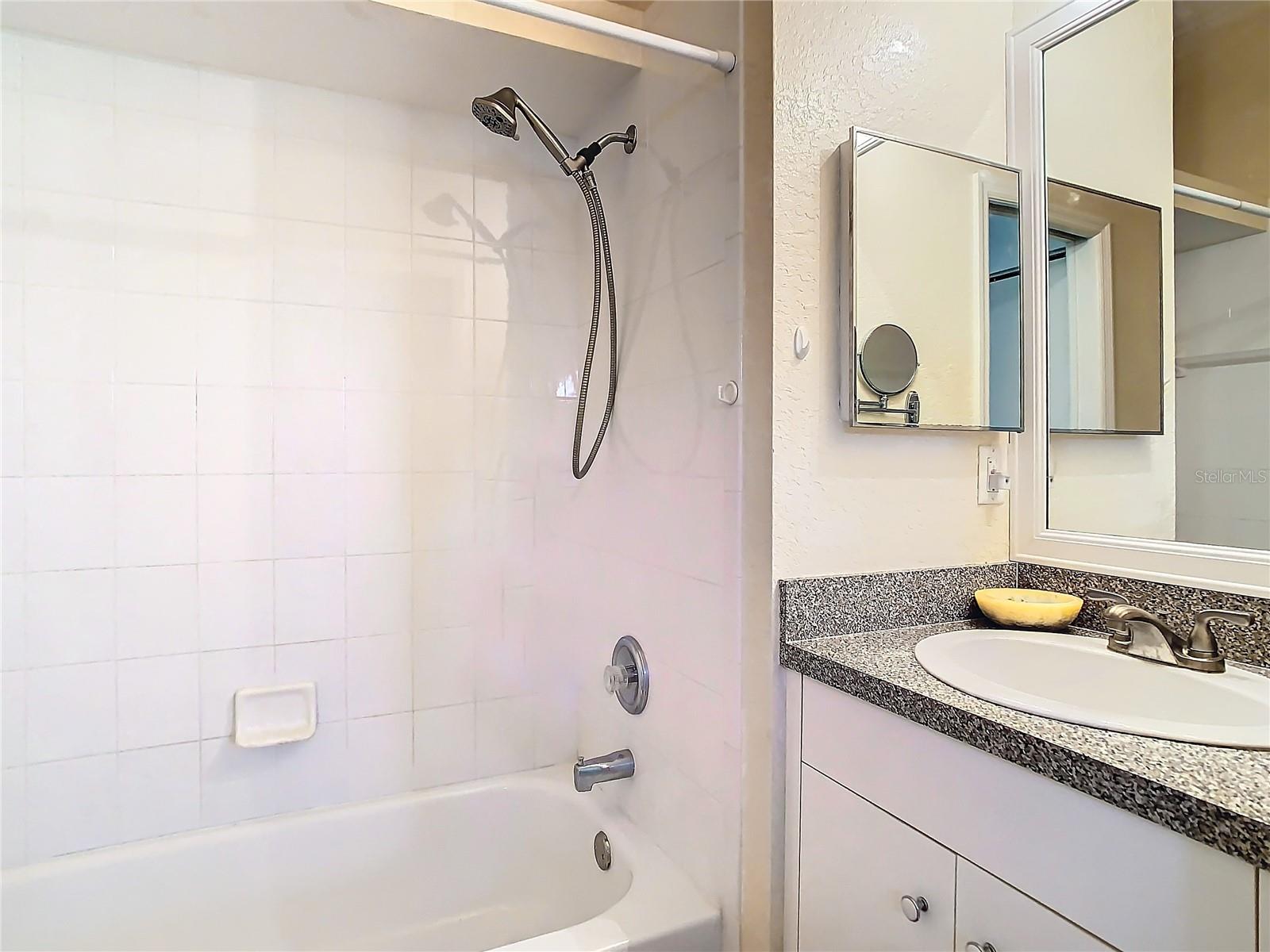 bathroom 2 is across from bedroom 2. Accessible via a pocket door.  Has a high vanity with a tub / shower combination.