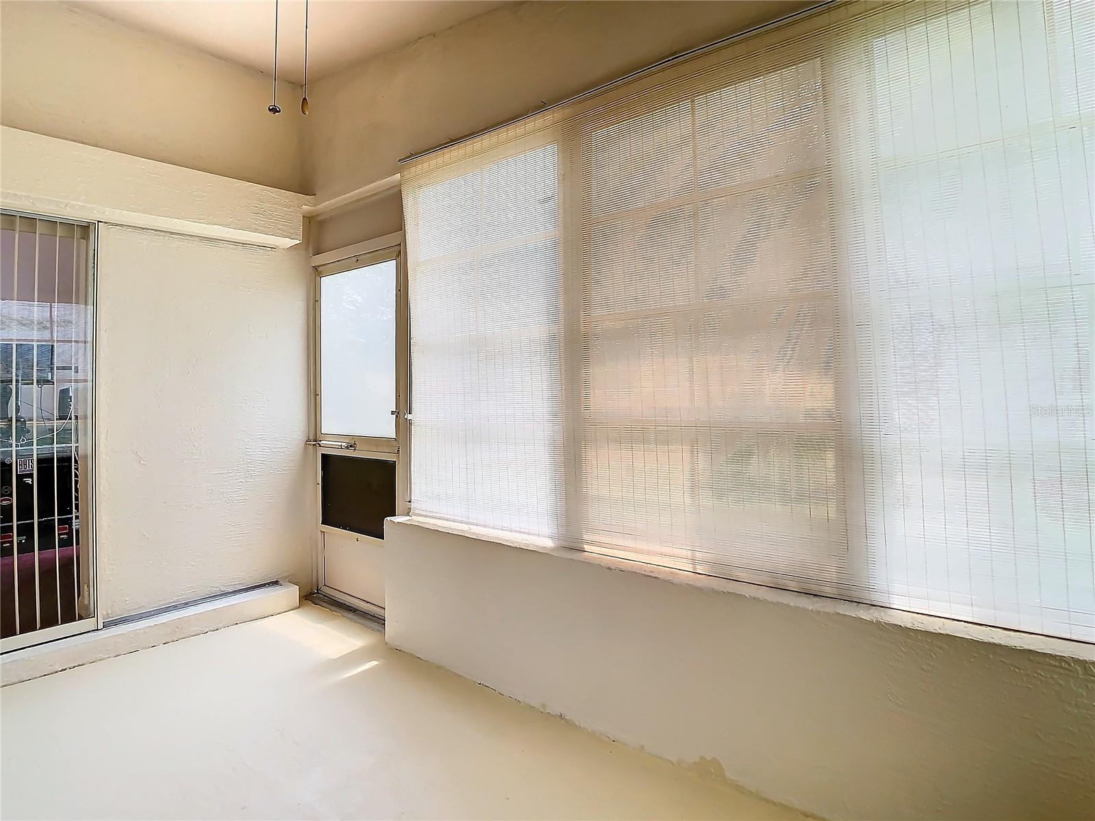 The lanai has a ceiling fan. Door opens out to the back yard. the glass door is a slider into the primary bedroom.