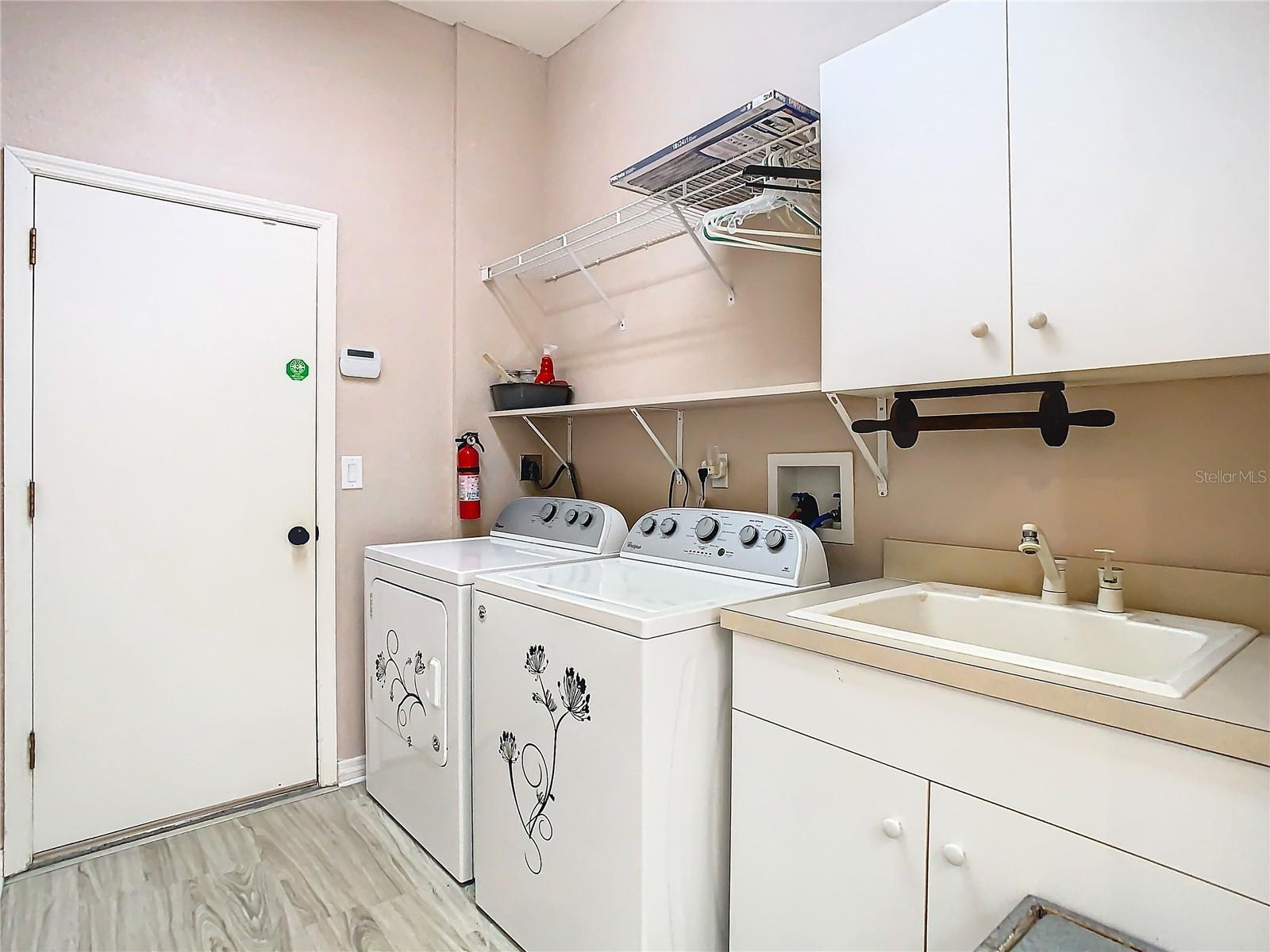 The laundry room is quite spacious. The sink, storage shelves, cabinets and a small utility closet make this a great space for all of your cleaning necessities. NOTE: The WASHER and DRYER DO NOT CONVEY with sale of the property.