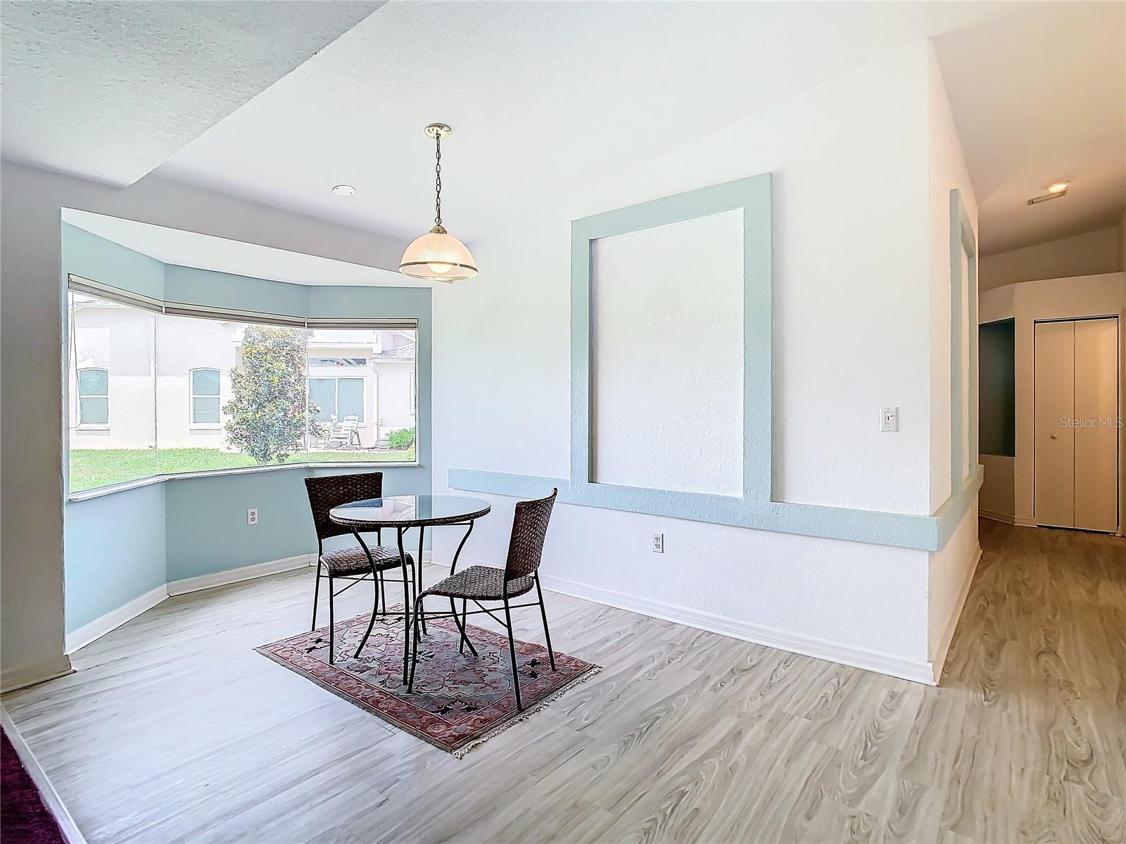 The dining area sits in one of two bay windows in this home. Sits on laminate flooring. Light and bright and in close proximity of the kitchen.