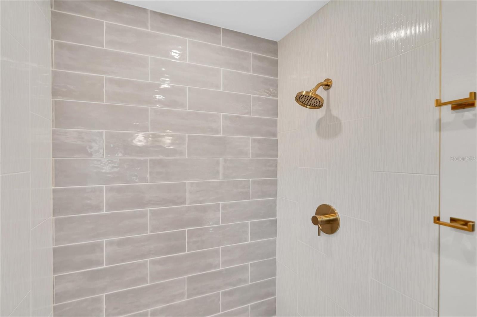 Baths feature gold finishes, subway tile, walk-in shower, pattern tile floor