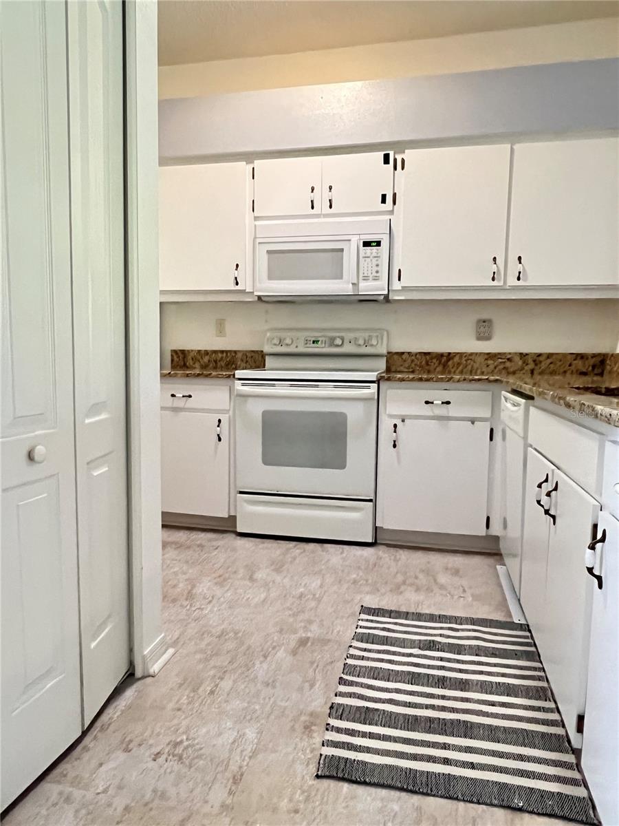 The kitchen has high ceilings, recessed lighting, and updated tile flooring.