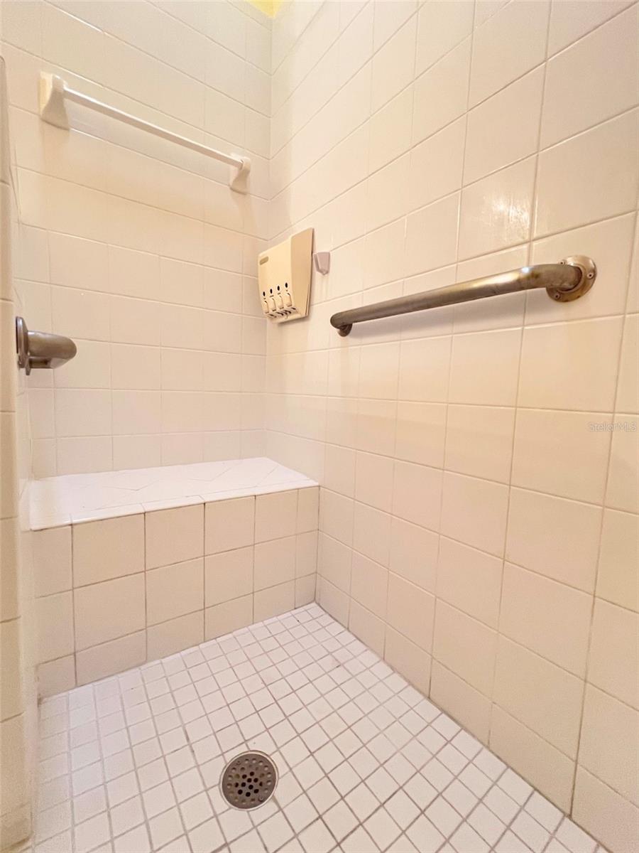 The shower has a bench to sit down when you need to.