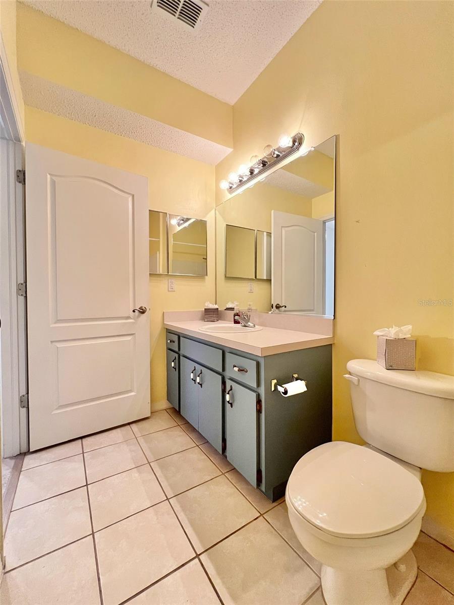 The second full bathroom has an oversized tub with grab bars, tile flooring, a newer toilet, and great cabinet space.