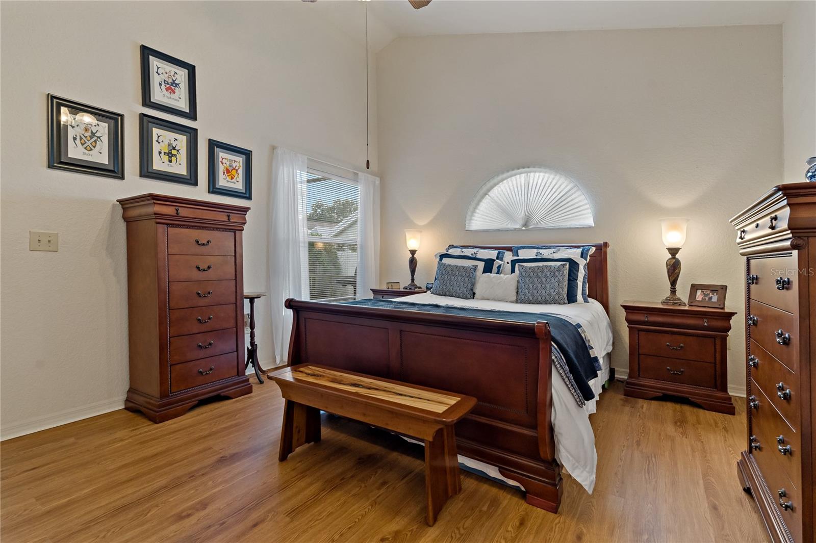 Primary Bedroom with Wood Laminate Flooring and Arched Window over Bed