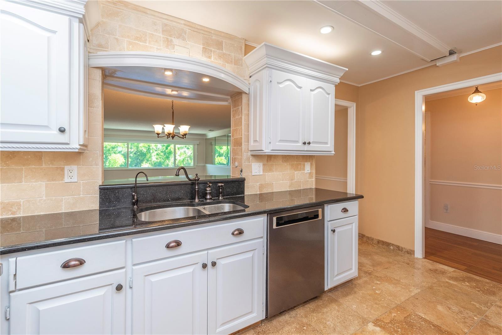 Kitchen with granite counters and pass through window to the dining room.