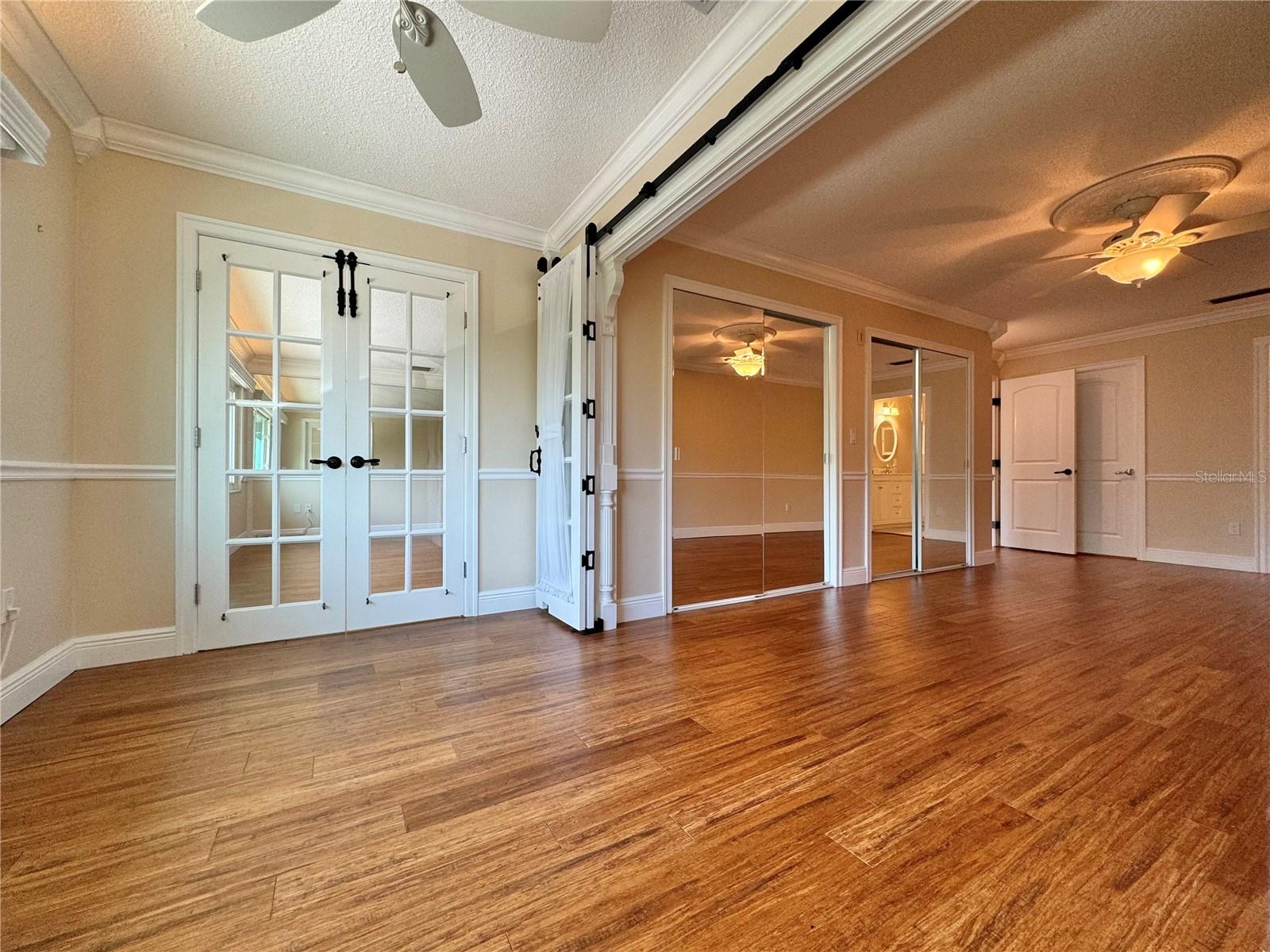 Sitting room with barn doors open to primary bedroom.