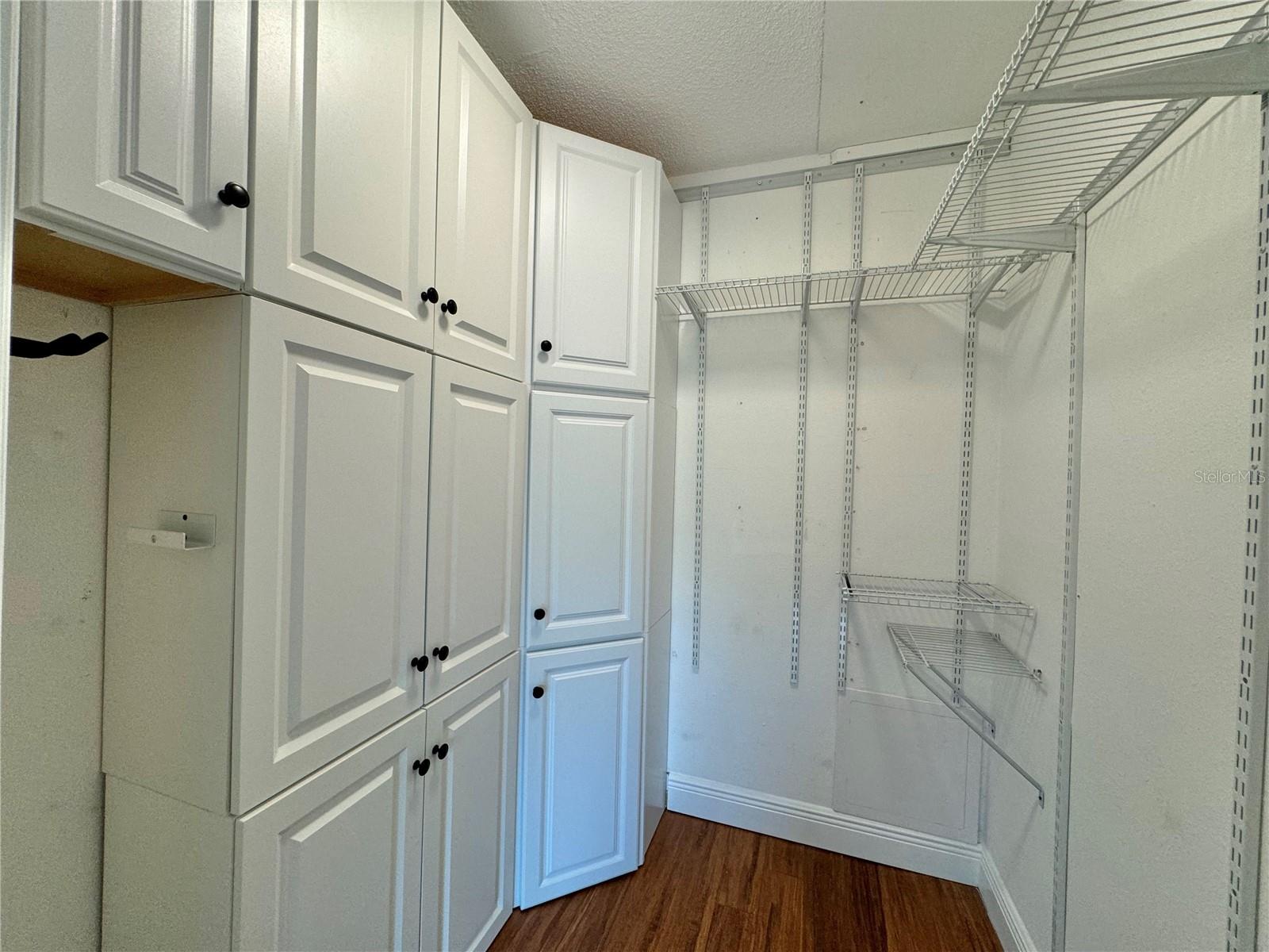 Guest bedroom has walk-in closet with built-in cabinets.