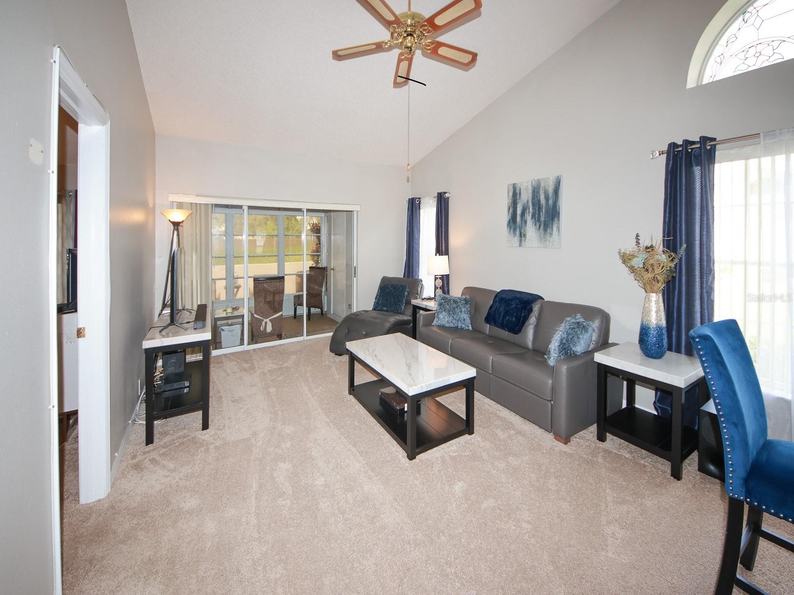 Living room with vaulted ceilings and sliding doors to the porch