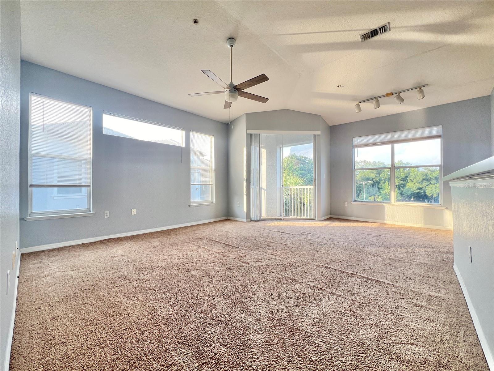 One big great room with lots of natural light, a lighted ceiling fan, and a screened-in balcony!