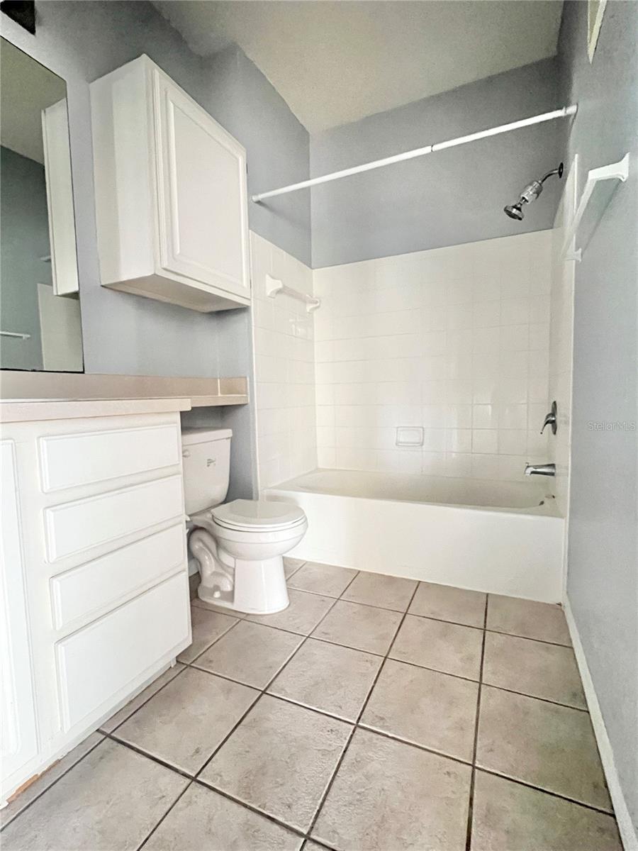 The bathroom has generous cabinet space, drawer space, and features ceramic tile flooring.