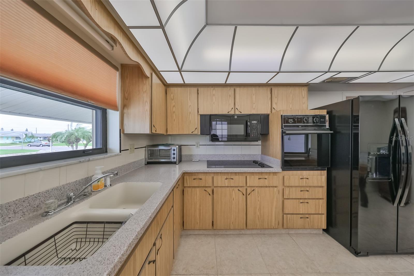 Attractive L shaped kitchen for maximum efficiency, with a view to the front yard.