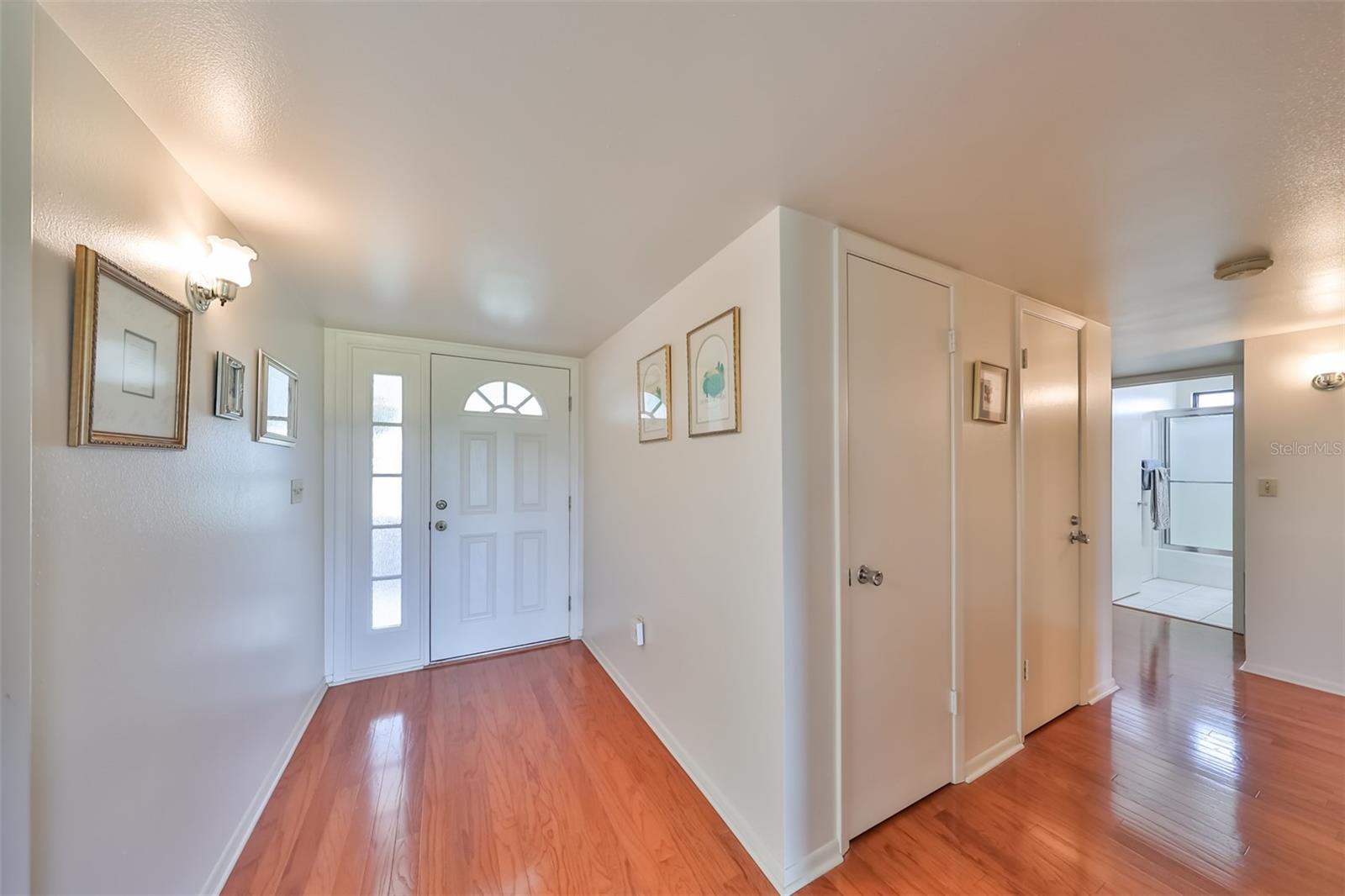 Front foyer is bright, sparkling clean with gleaming laminate flooring.  Notice all of the closet storage!