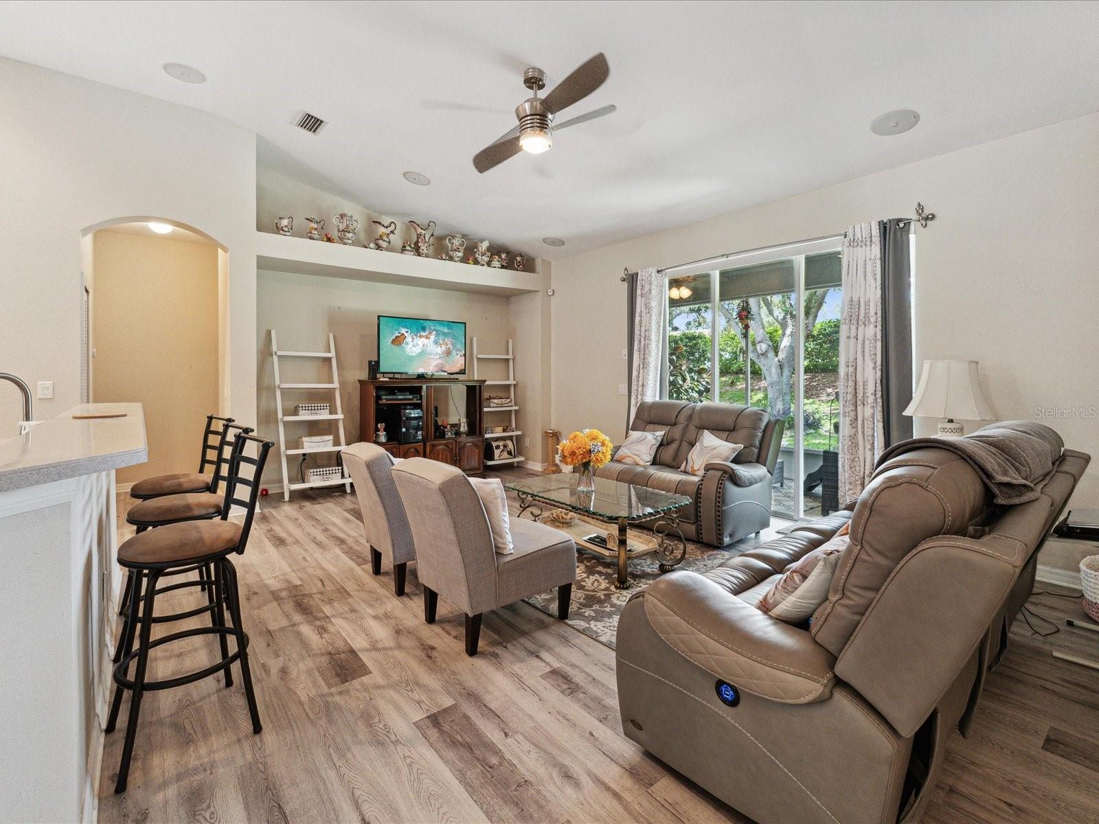 This kitchen/great room combination features updated wood look floors and decorative wall niches.