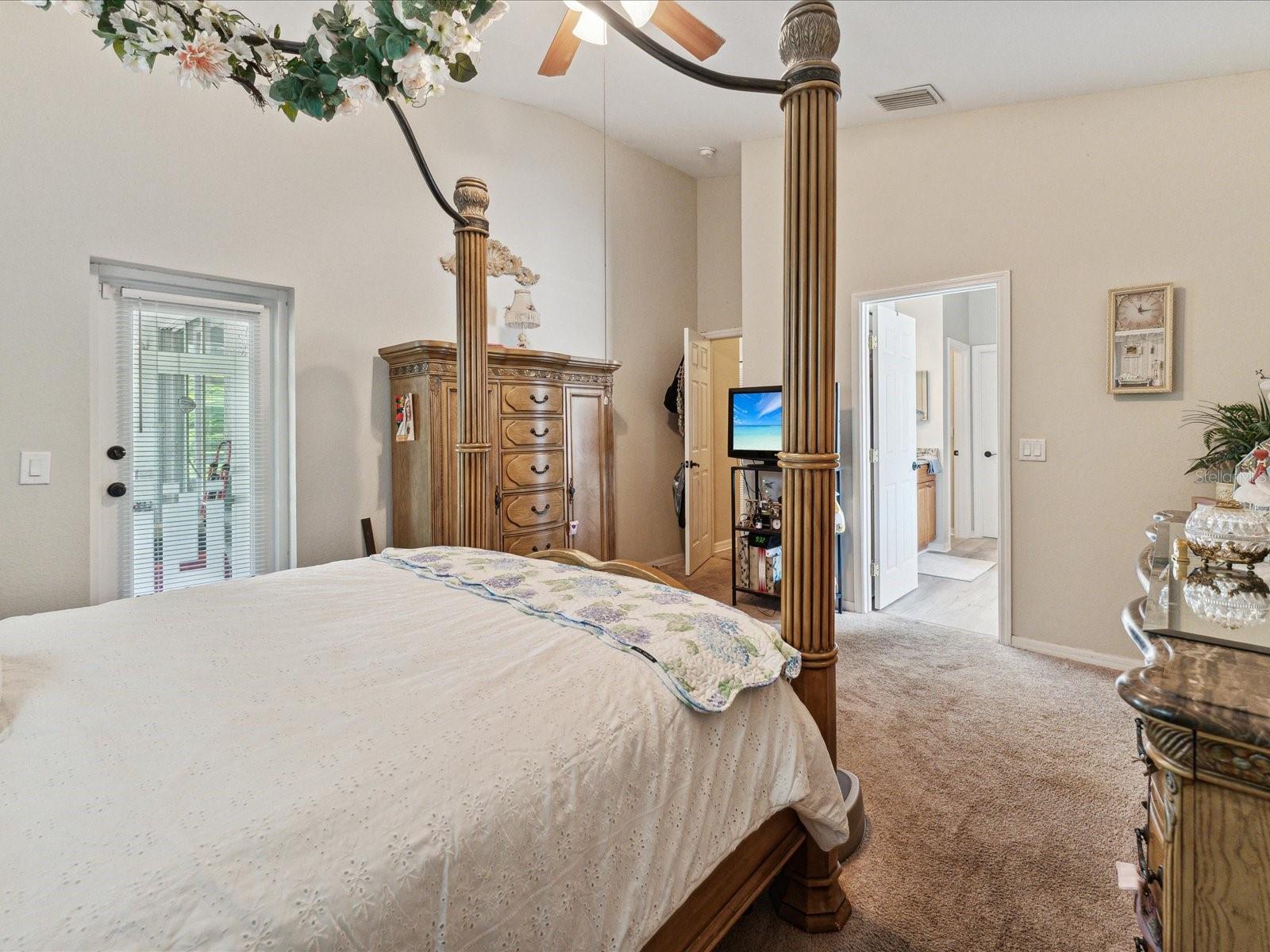 The primary bedroom features vaulted ceilings, ceiling fans and an outdoor access to the lanai.