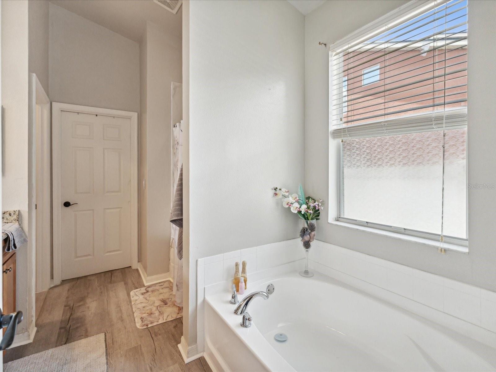 Luxuriate in this full sized tub or in the newly renovated shower! The updated floors that lead to the walk-in closet give the primary bathroom a polished finish.