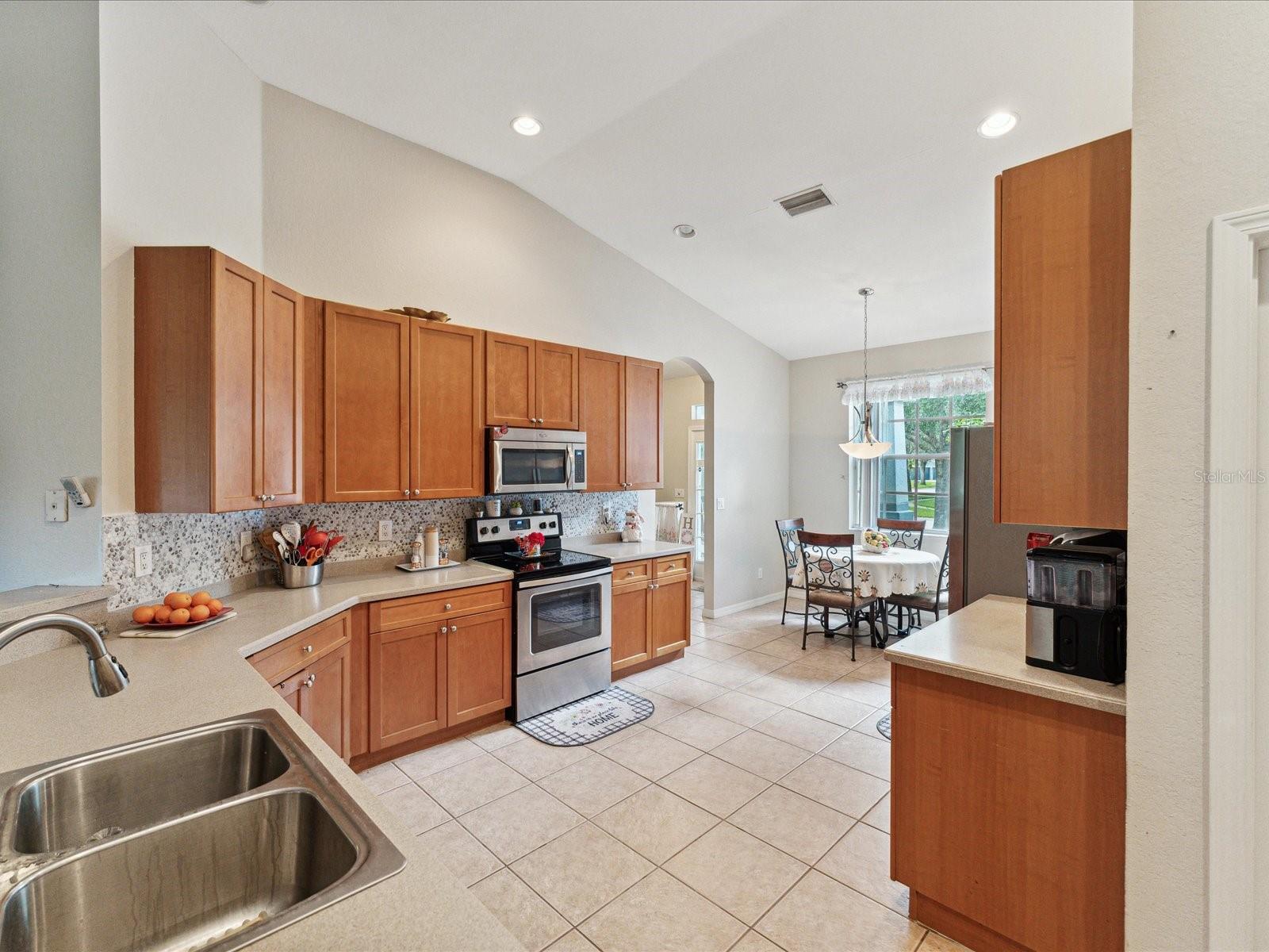 The stainless steel appliances accent the neutral counters and the brand new backsplash.