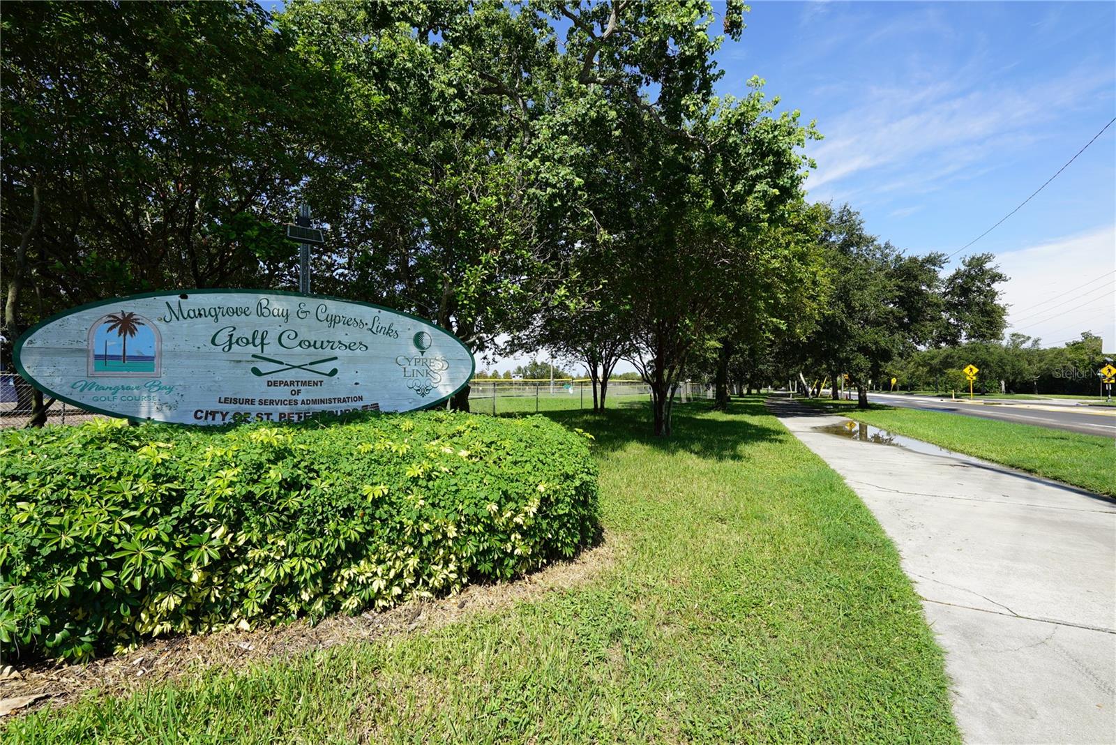 WALKING PATH ALONG THE PLAYGROUND AND THE GOLF COURSE SIGN ACROSS THE STREET