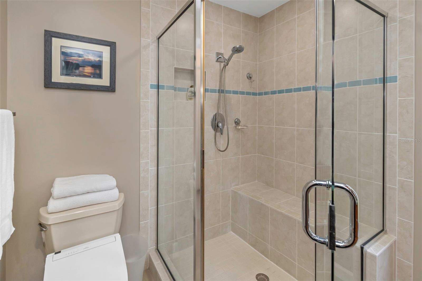 Glass enclosed walk-in shower.