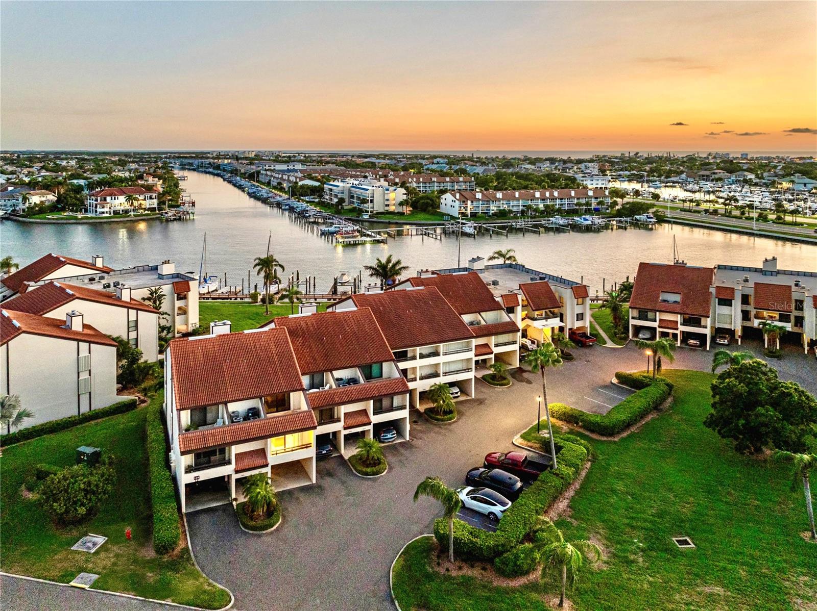 Aerial view of the front of the townhouse with canal view. Unit has the light on.