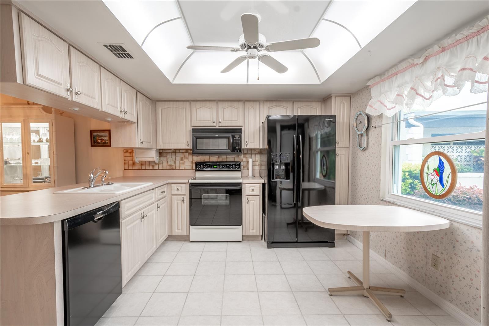 The kitchen features a lighted dome ceiling with ceiling fan, ceramic tile flooring and room for a breakfast table.