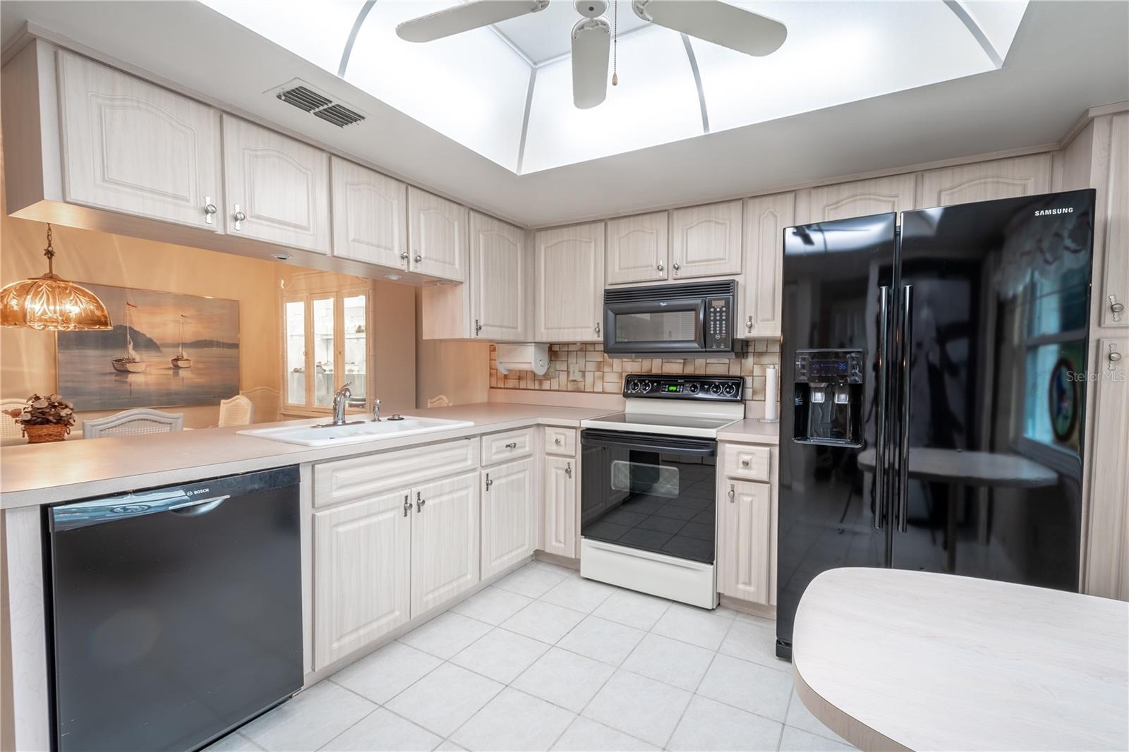 The kitchen features a full suite of appliances including a French Door refrigerator with ice maker and water dispenser, an electric range, a microwave and dishwasher. Plenty of cabinets and counter space.