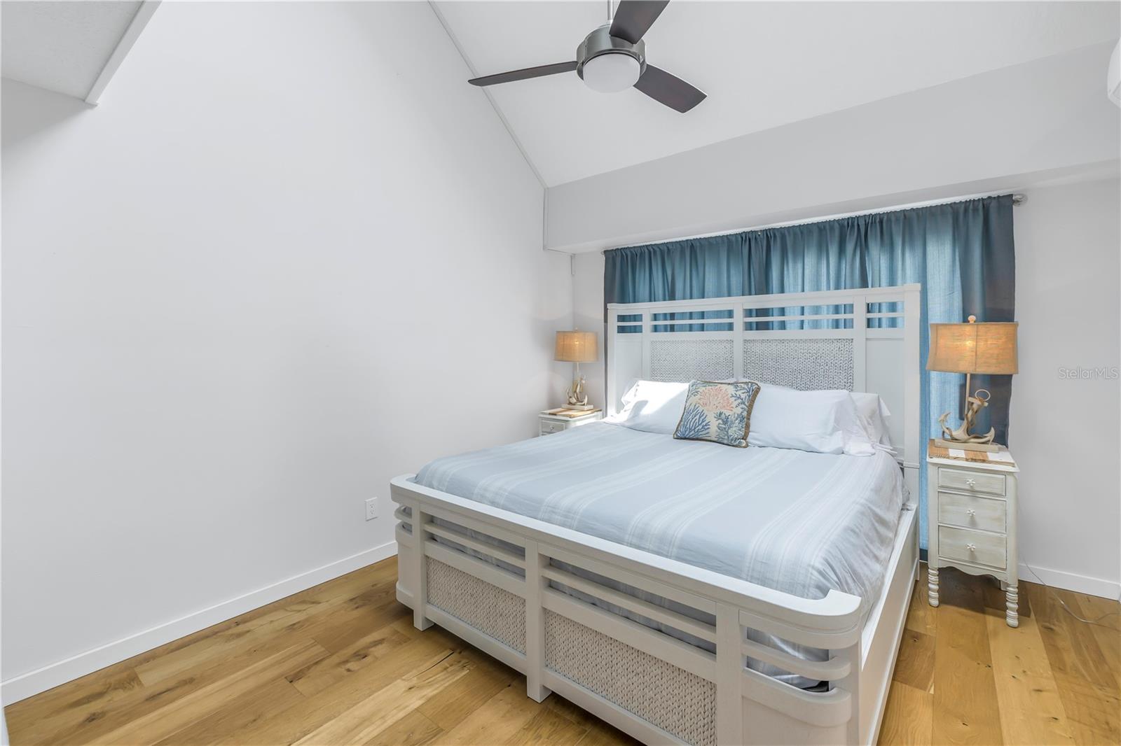 Primary bedroom has vaulted ceiling and sliding doors to a balcony