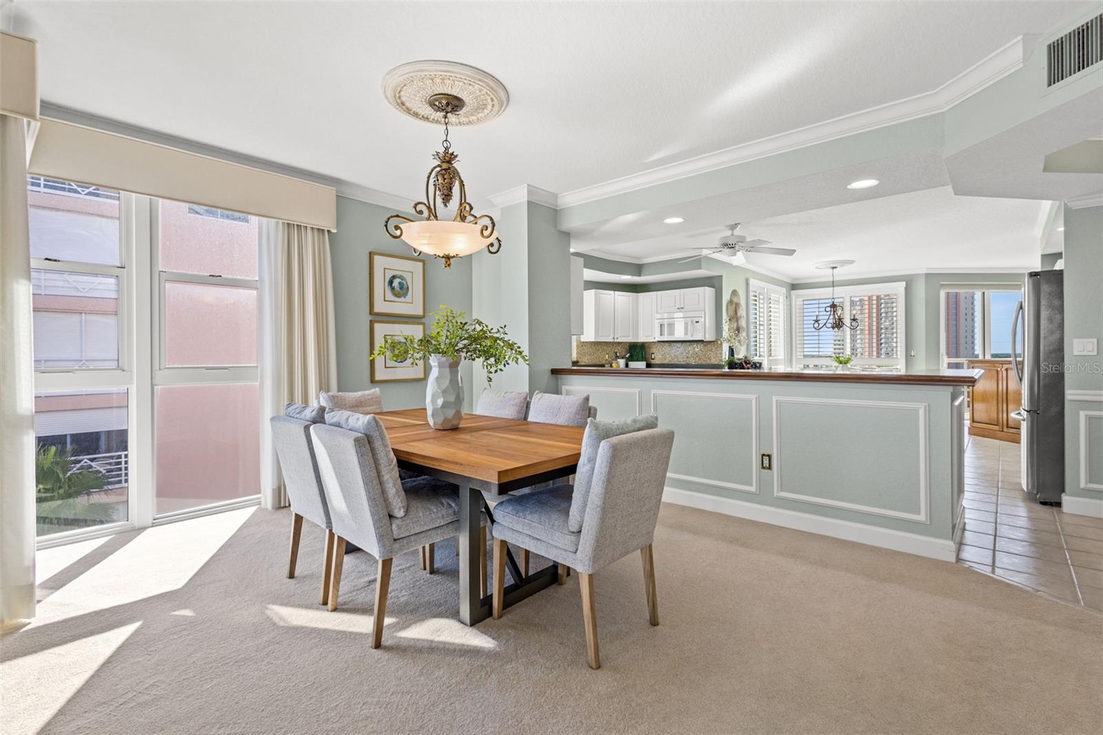 Dining area is open to the living room and kitchen with bright windows.