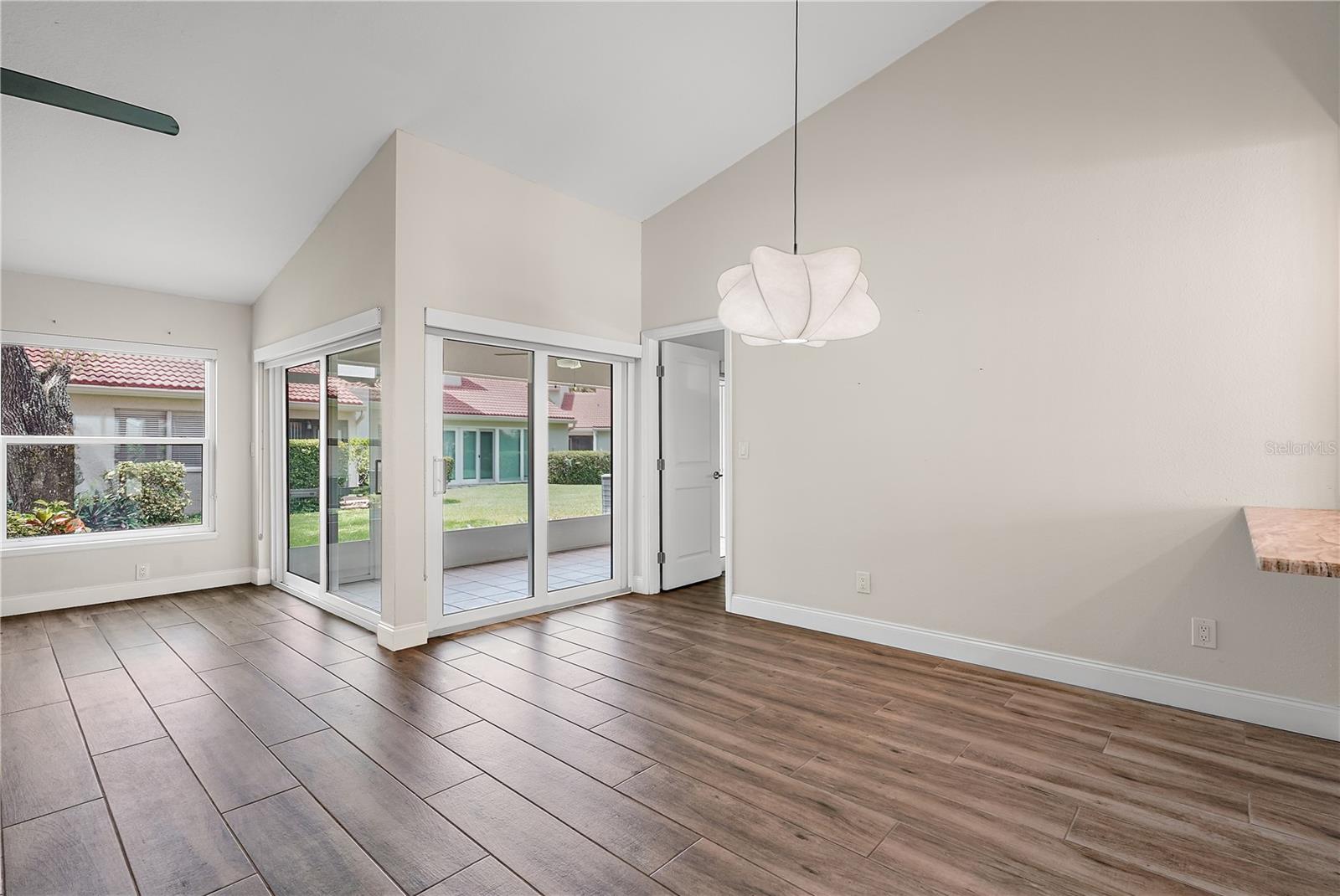 View of the main living area.  The hanging light fixture is where the dining room table could go.  This is a view towards the patio area.  The condo is currently unfurnished