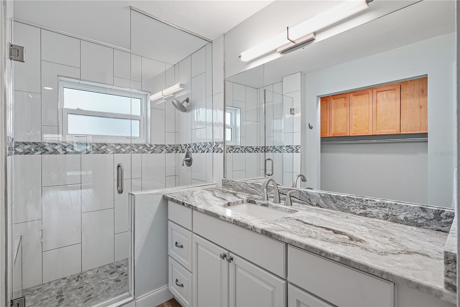 Unfurnished master bathroom displaying the ample counter space on the vanity and the beautiful shower.