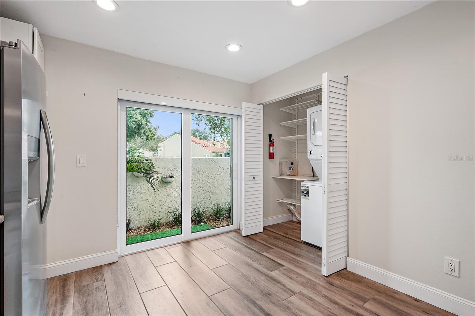 Unfurnished kitchen area.  The sliding glass doors lead to the front patio where you can grill if you desire.  The built in cabinets/closet is displayed to the right of the sliding glass door.